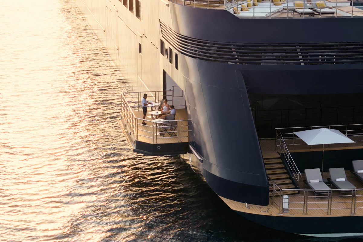 Aerial drone view of guests dining on the marina terrace over water on the Evrima luxury yacht cruise ship. Source: The Ritz-Carlton Yacht Collection