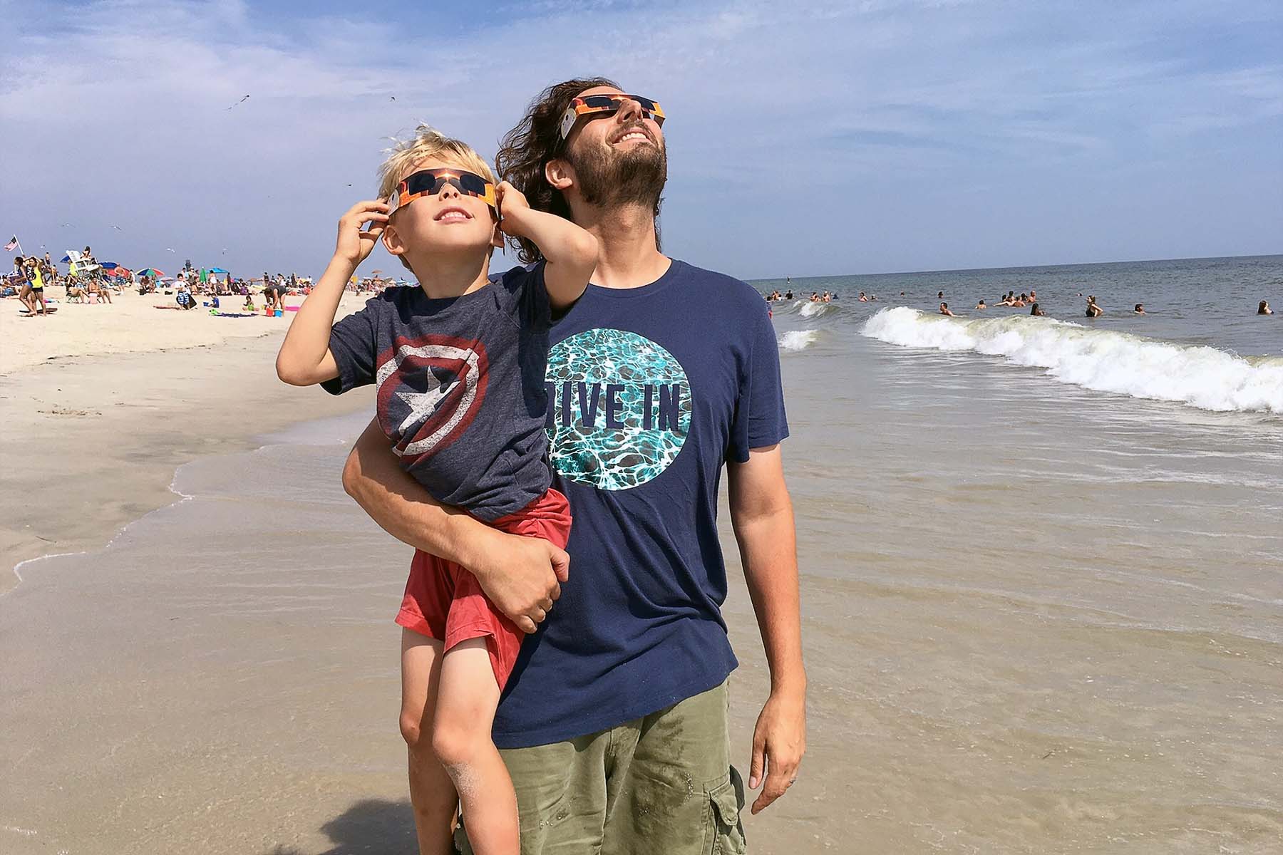 A man and child sungazing during an eclipse. 